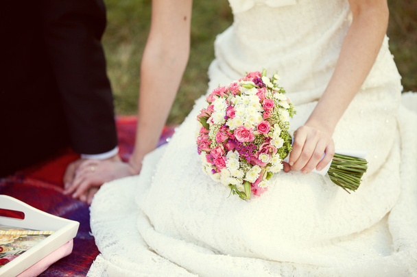 Rózsaszín és fehér menyasszonyi csokor a kezében a menyasszony - Fotó, kép