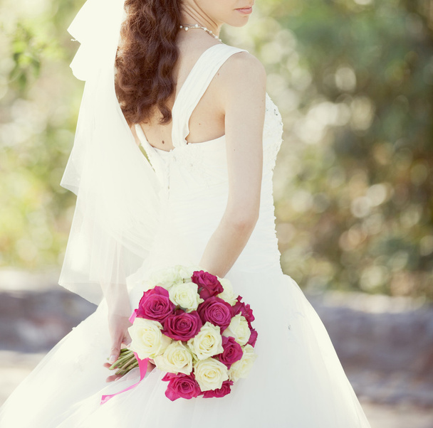 Pink and white wedding bouquet of roses in the hands of the brid - Photo, image