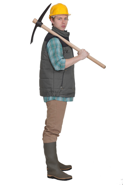 Young bricklayer posing with pickaxe - Φωτογραφία, εικόνα