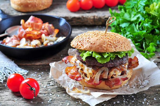 juicy homemade double burger beef with fried onions on a wooden background - Fotoğraf, Görsel