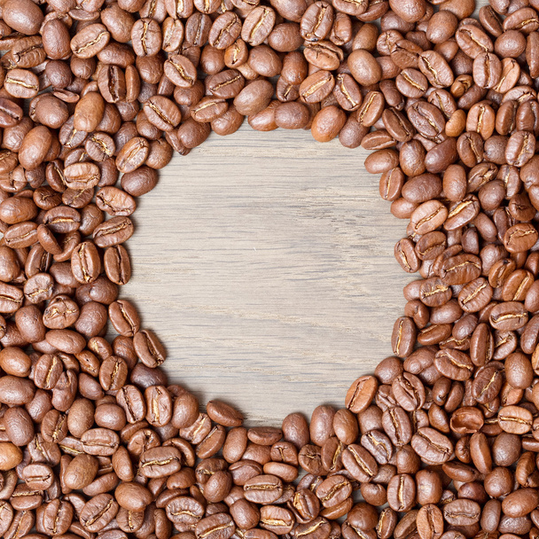 Primer plano de granos de café tostados oscuros en una mesa rústica de madera vieja
 - Foto, Imagen