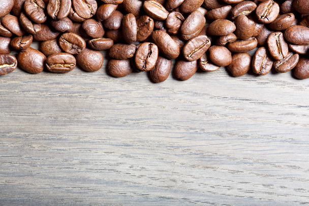 Coffee beans on wood background. - Foto, afbeelding
