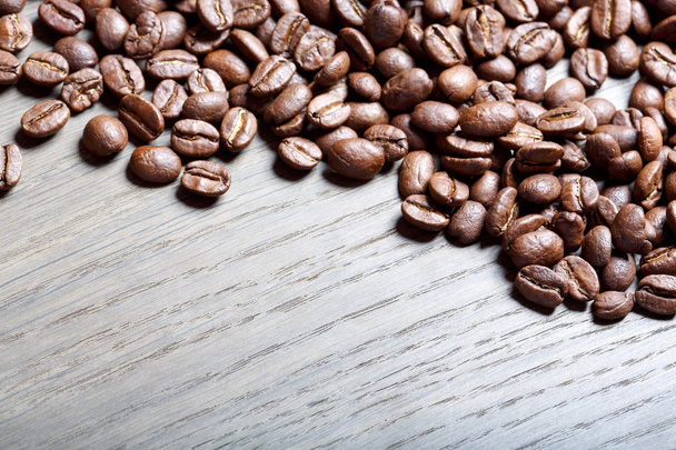 Granos de café sobre el fondo marrón de madera
. - Foto, Imagen