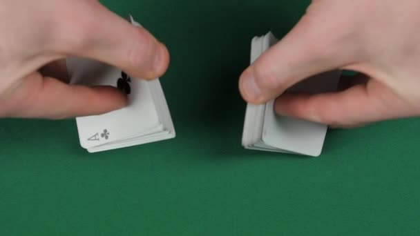 Playing cards being shuffle, on a green surface by magician, close up, slow motion - Imágenes, Vídeo