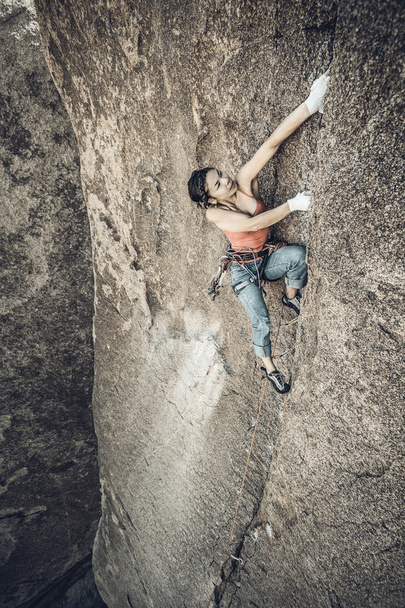 rock klimmer klampt zich vast aan een klif. - Foto, afbeelding