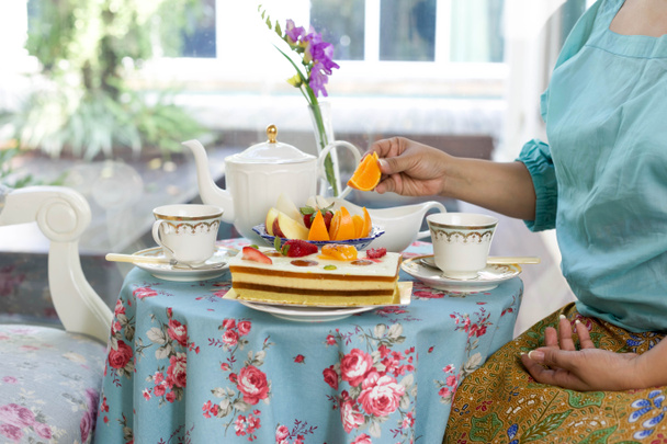 Azjatyckie kobiety o herbatę i ciasto i świeże owoce - Zdjęcie, obraz