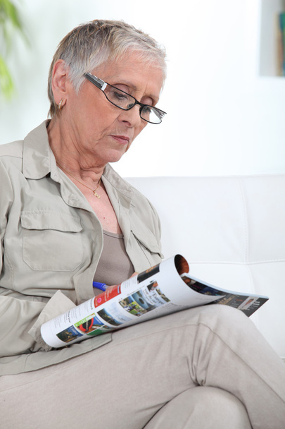 Older lady reading magazine - Foto, afbeelding