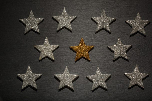 Silver and one golden stars in a row on dark - Foto, afbeelding