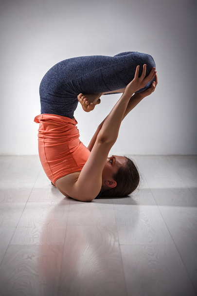 Sporty fit woman practices inverted yoga asana - Photo, Image