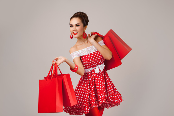 Happy Woman Holding Up Shopping Bags. Pin-up retro style. - Valokuva, kuva