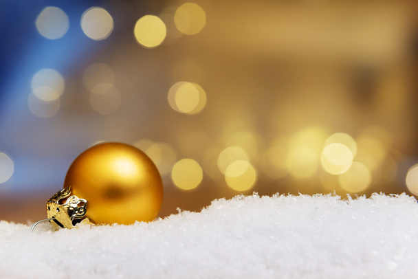 Золотая безделушка на снегу
 - Фото, изображение