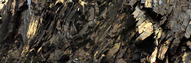 schwarze, goldene Felsen - abstrakter Hintergrund aus Vulkangestein - Foto, Bild