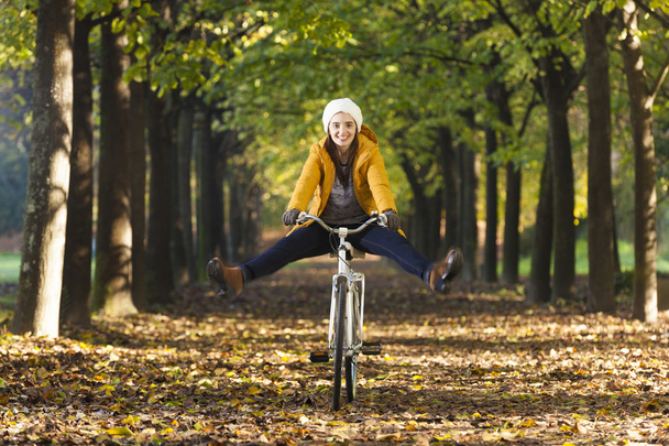 Happy smiling girl riding a bicycle at the park - Foto, imagen