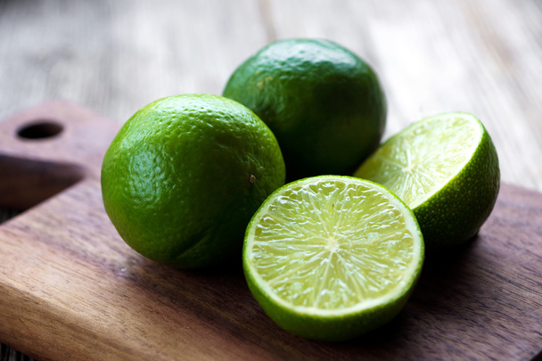 Whole and sliced fresh limes - Foto, imagen