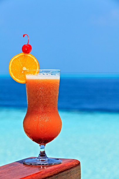 Glas van drank is op een strand-tabel - Foto, afbeelding