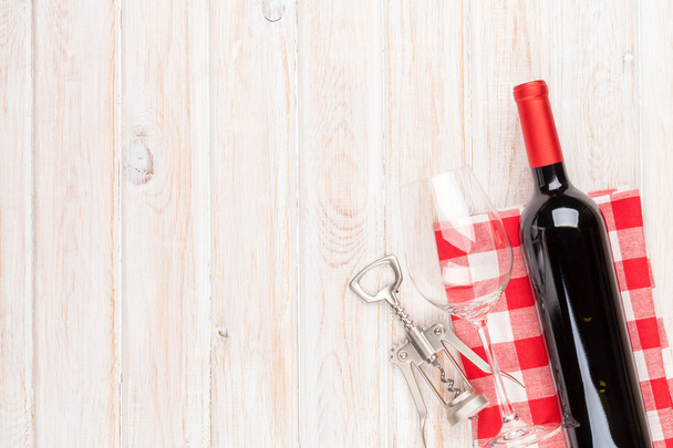 Red wine bottle, glass and corkscrew - Foto, afbeelding