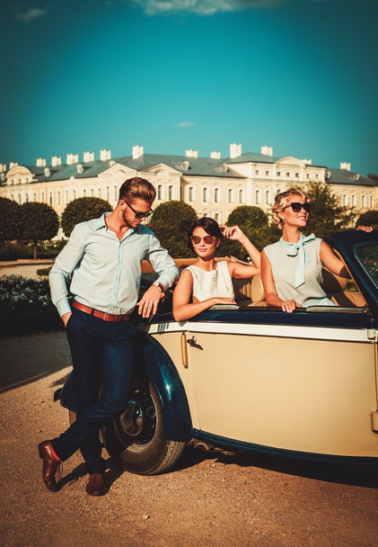 Rijke vrienden in een klassieke cabriolet  - Foto, afbeelding