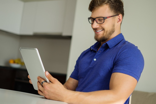 Hombre guapo usando tableta PC en casa
  - Foto, imagen