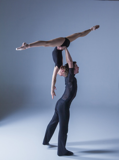 two young modern ballet dancers on blue studio background - 写真・画像