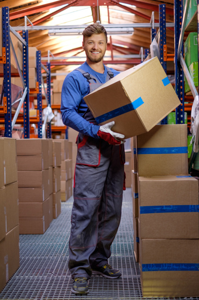 Porter carrying boxes in a warehouse  - Foto, imagen