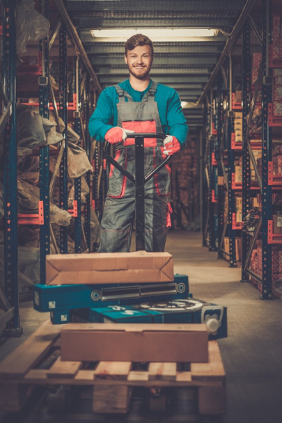 Loader using hand pallet truck in a warehouse  - Photo, Image
