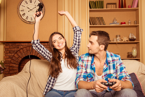 couple in love at home playing games joysticks, she won - Photo, Image