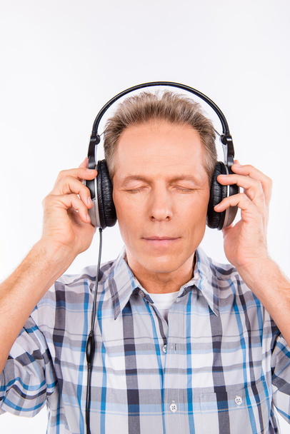 Aged calm hipster with headphones listening to music - Foto, Imagen