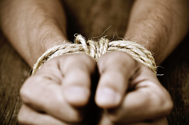 the hands of a young man tied with rope - 写真・画像