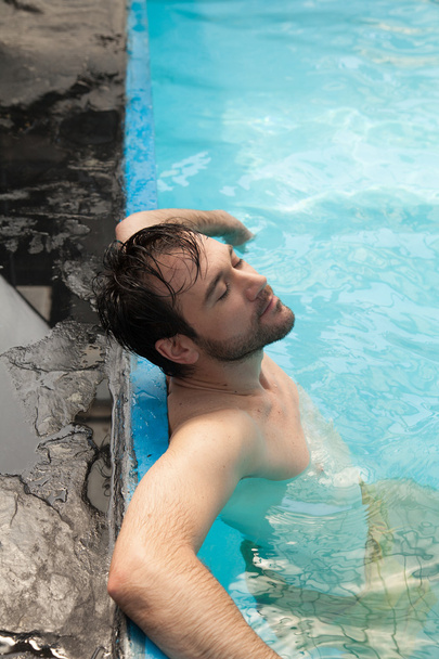 man relaxing in pool - Foto, Bild