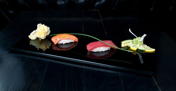 Nigiri sushi servido en un plato negro
 - Foto, imagen