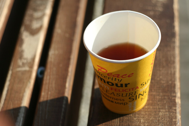tasse en papier avec thé sur le banc en bois
 - Photo, image