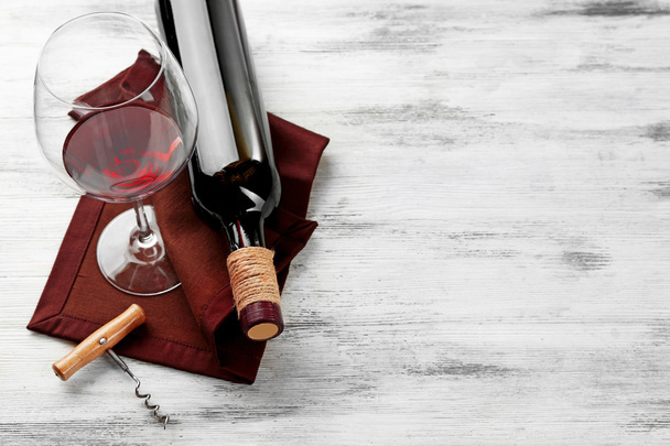 Wine with corkscrew on wooden table - Foto, afbeelding