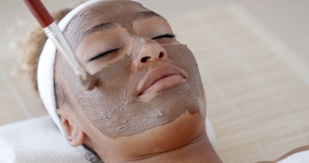 Woman with clay facial mask - 写真・画像