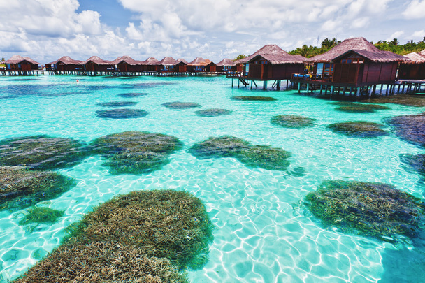 over water bungalows en lagune met koraal - Foto, afbeelding