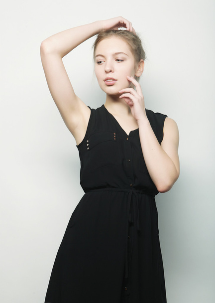 young fashion blond woman in black dress posing in studio - Foto, afbeelding