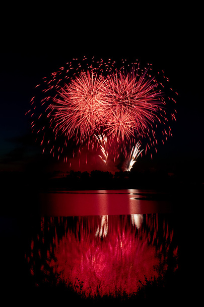 水に映る赤い花火 - 写真・画像