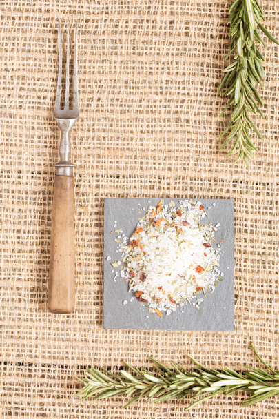 Sel aux épices sur plaque sombre avec romarin et fourchette antique
 - Photo, image