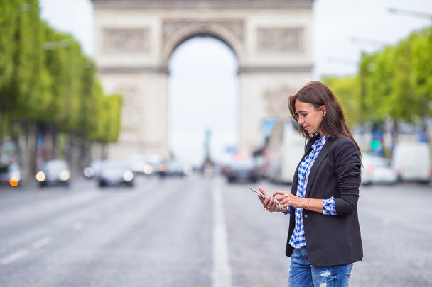 パリのシャンゼリゼに携帯電話を保持している美しい女性 - 写真・画像