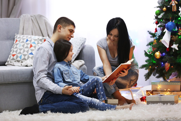 Happy family read book in the decorated Christmas room - Photo, Image