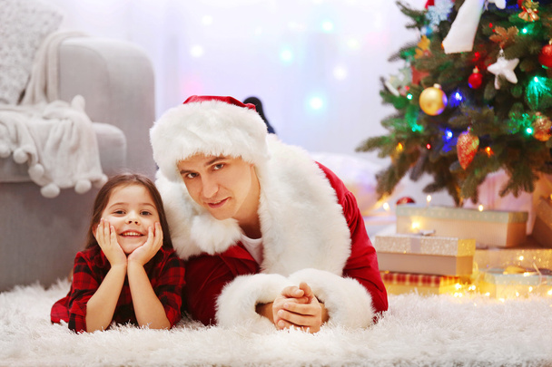 Happy father and daughter on the floor in the decorated Christmas room - Foto, Bild
