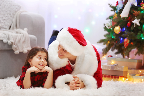 Happy father and daughter on the floor in the decorated Christmas room - Foto, imagen