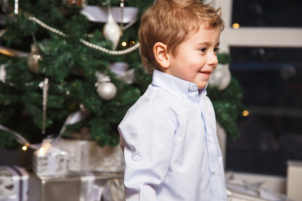 Portrait of a little boy playing over christmas background - Фото, изображение