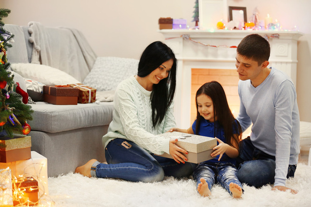 Happy family on the floor with gifts in the decorated Christmas room - Foto, Bild