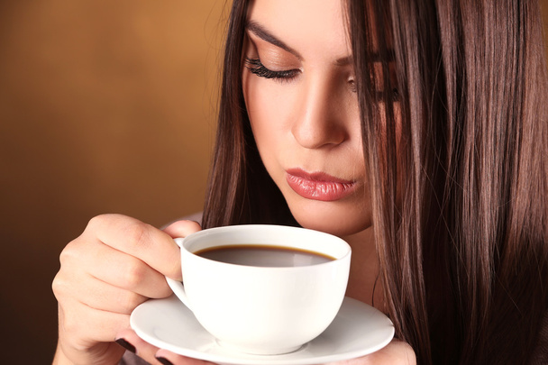Woman holds cup of coffee and saucer in hands, close up - Фото, изображение
