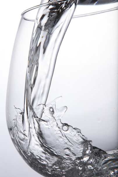 Pouring water to the container with white background - Foto, Imagen
