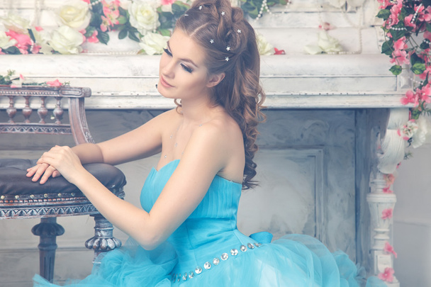Beautiful young woman in gorgeous blue long dress like Cinderella with perfect make-up and hair style - Photo, image