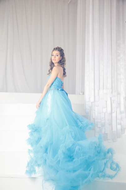 Beautiful young woman in gorgeous blue long dress like Cinderella with perfect make-up and hair style - Φωτογραφία, εικόνα