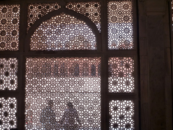 Emberek sittinh-indiai templom faragott márvány függöny mögött - Fotó, kép