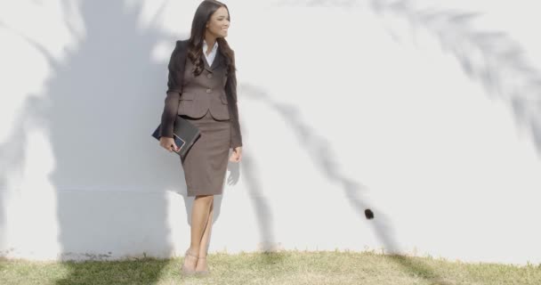 Mulher de negócios ficando na frente de uma parede
 - Filmagem, Vídeo