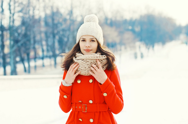 Pretty young woman wearing a red coat, knitted hat and scarf in  - Fotoğraf, Görsel